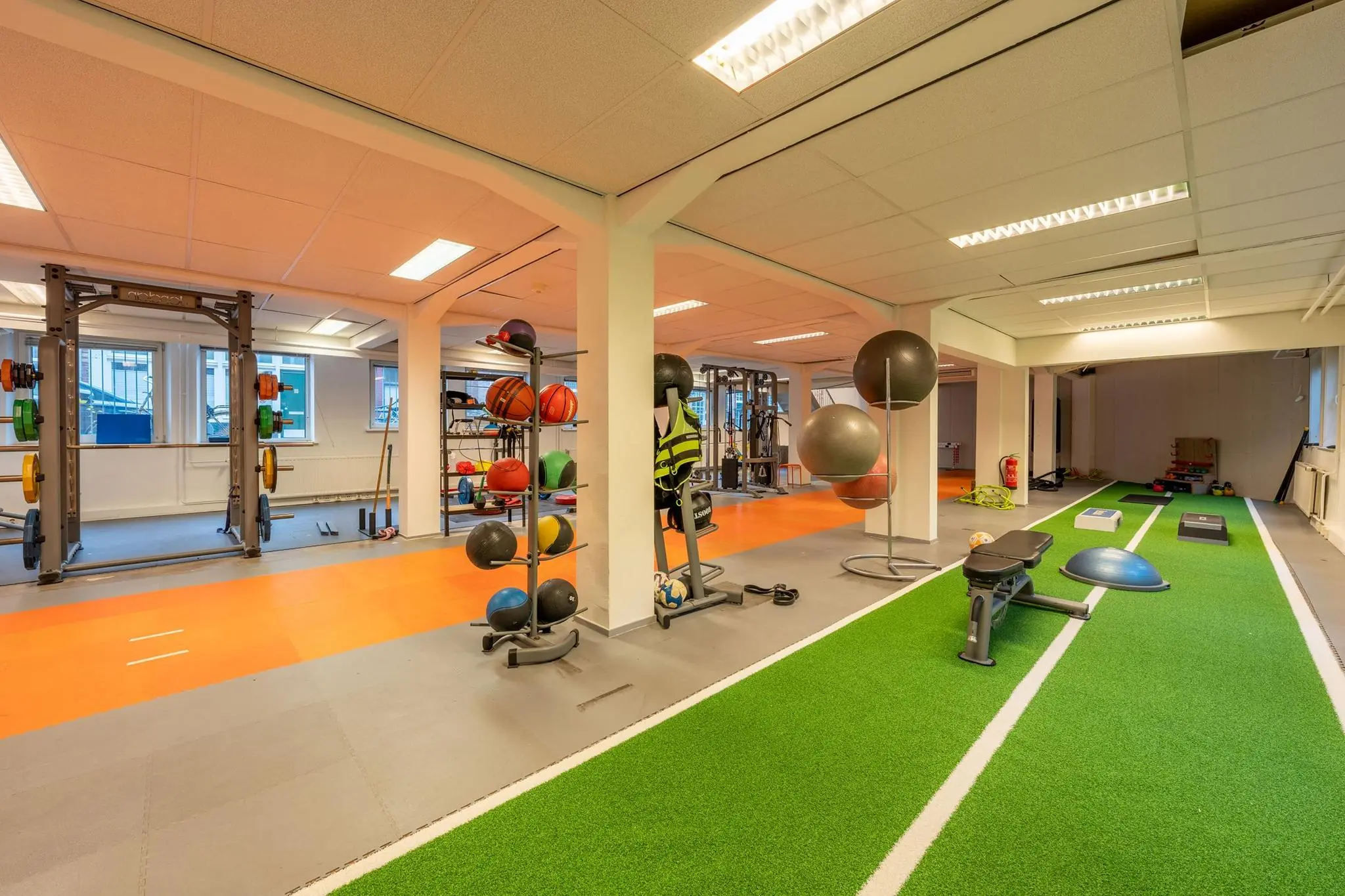 Moderne fitnessruimte aan de Admiraal de Ruijterweg met trainingsapparatuur, vrije gewichten en een indoor sprintbaan.